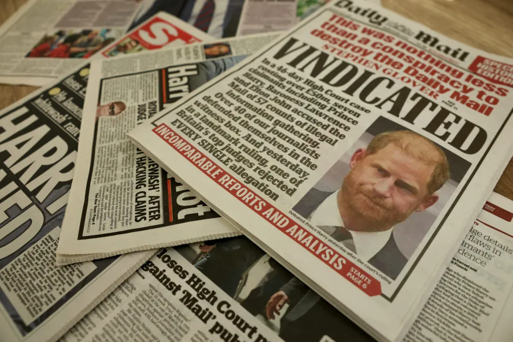 A photo illustration shows British newspapers reporting on Prince Harry’s High Court case — a reminder of how legal battles have shaped public perception.