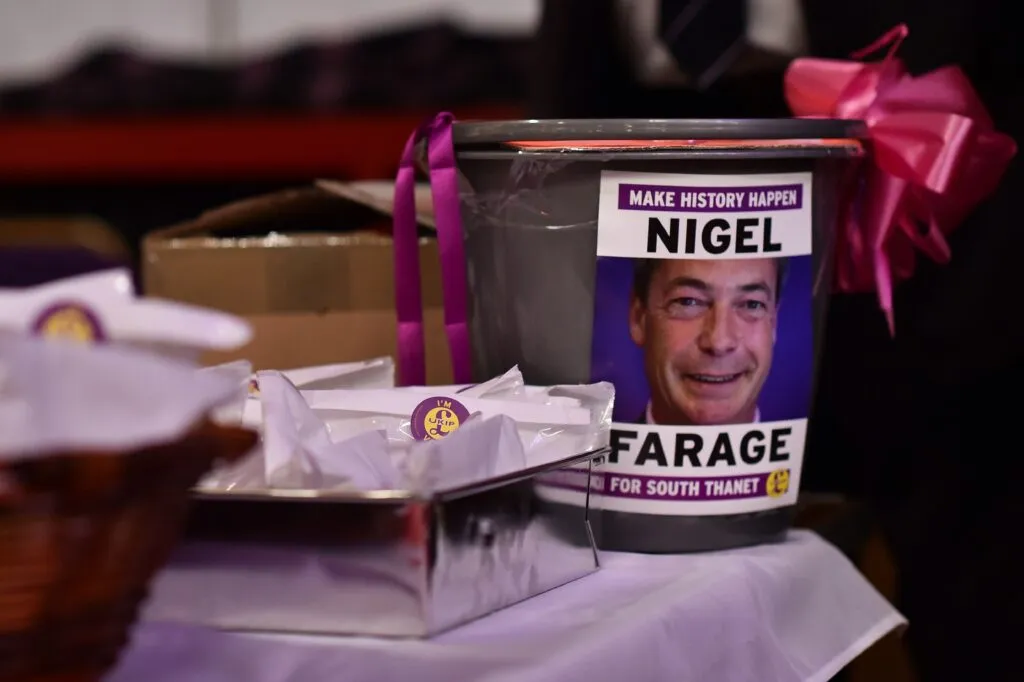 A donations bucket featuring Nigel Farage at a conference in 2015